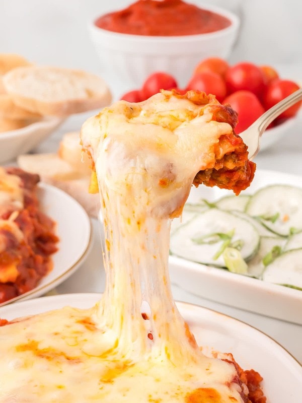 A spoonful of extra cheesy Lazy Lasagna served on a white plate.