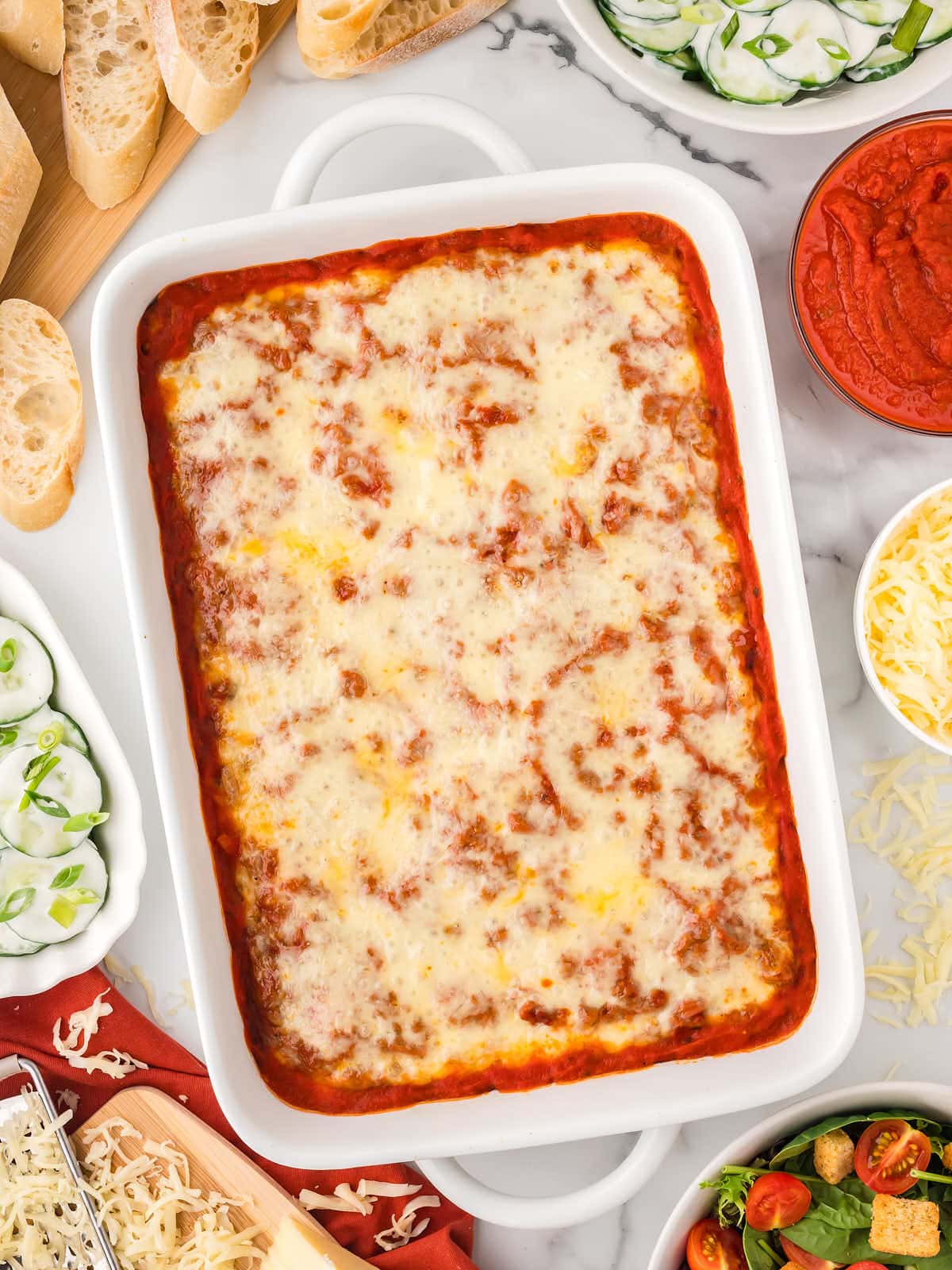 Topdown view of an cheesy Lazy Lasagna served in a white casserole dish.