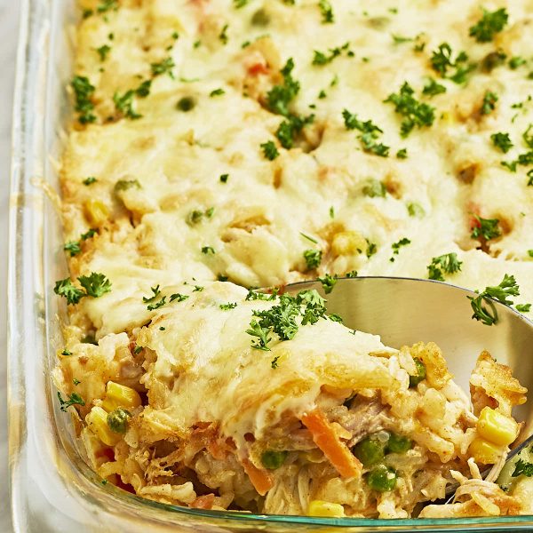 A spoonful of chicken and rice in a baking dish.