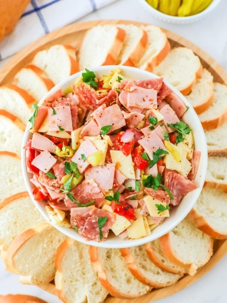 An Italian Hoagie Dip with bread and pickles.