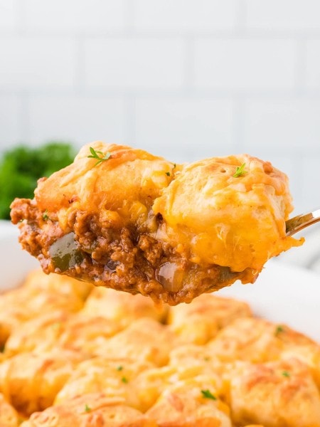 A serving spoonful of Sloppy Joe Casserole being moved from a casserole dish.