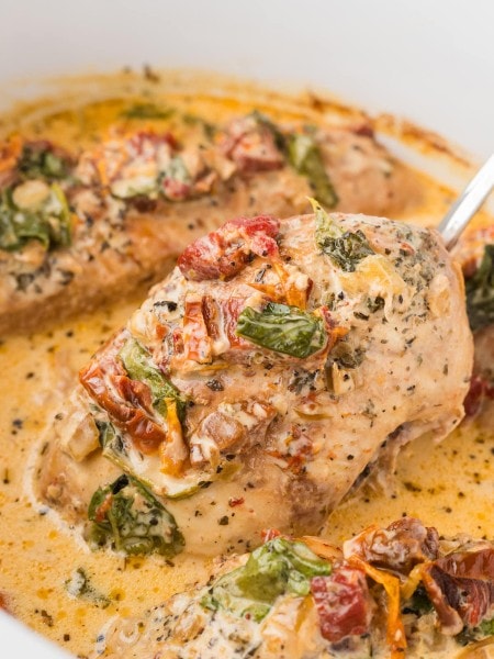 Transferring a Tuscan Chicken breast out of the Crockpot.