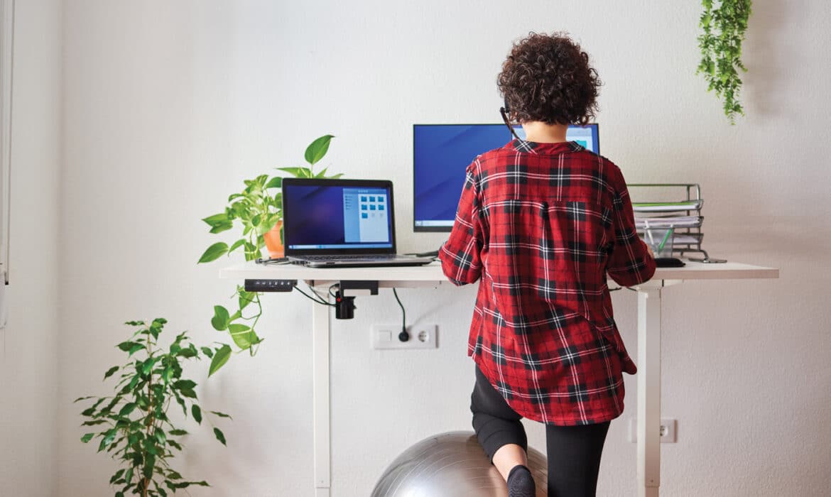 Woman working at a standing desk to avoid being sedentary and getting some movement