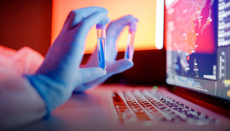 Person performing medical research holding glass tubes