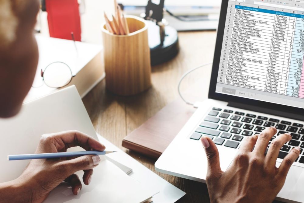 Person working with a spreadsheet on a laptop