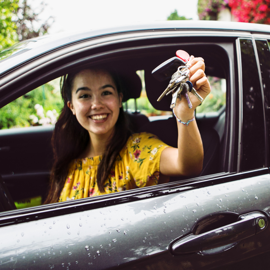 Woman in new car waving keys