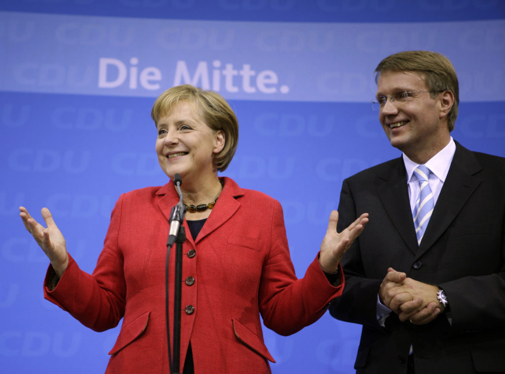 Angela Merkel, German chancellor and leader of the conservative Christian Democratic Union party, and party general secretary Ronald Pofalla (right) greet supporters after the first exit polls in the German general election at party headquarters in Berlin on Sept. 27, 2009. Photo by Kai Pfaffenbach/Reuters