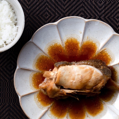 例の煮汁で仕上げたカマの煮つけ。煮汁に浮く尋常でない量の油を見よ。甘辛の味付けでご飯が進む進む。