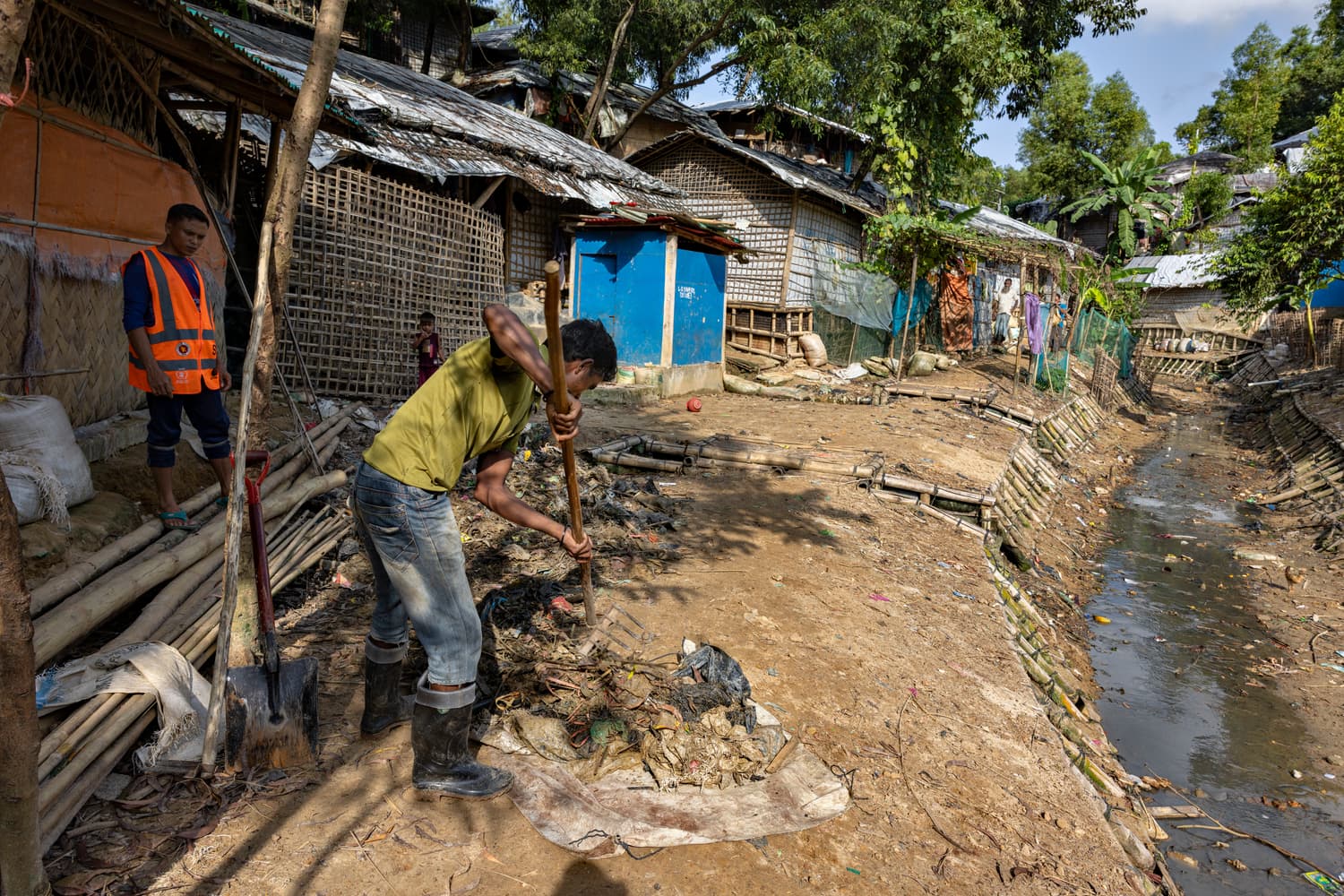 Trabajadores retiran basura de un arroyo en el asentamiento de refugiados de Kutupalong como parte de una iniciativa encabezada por Mohammed Anower y su grupo de jóvenes.