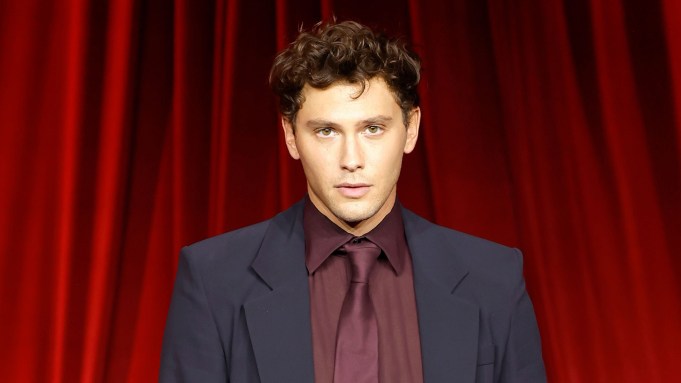 Cooper Koch poses in front of a red curtain.