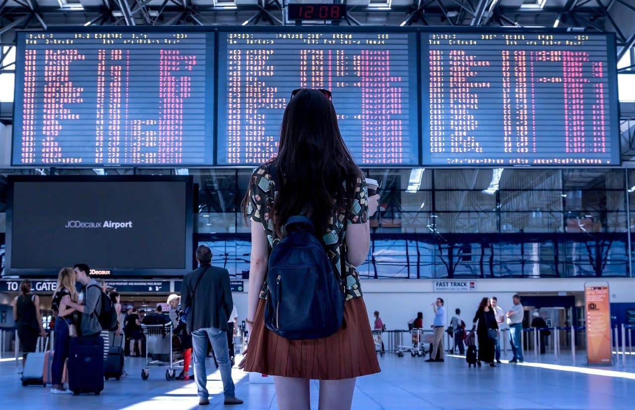 Mujer mirando los horarios de los vuelos en el aeropuerto