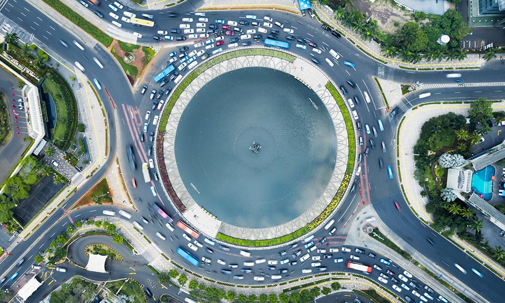 JAKARTA, Indonesia - December 17, 2019: Tilted top down horizontal view of a fountain in the middle of a roundabout in Jakarta city at sunny morning.