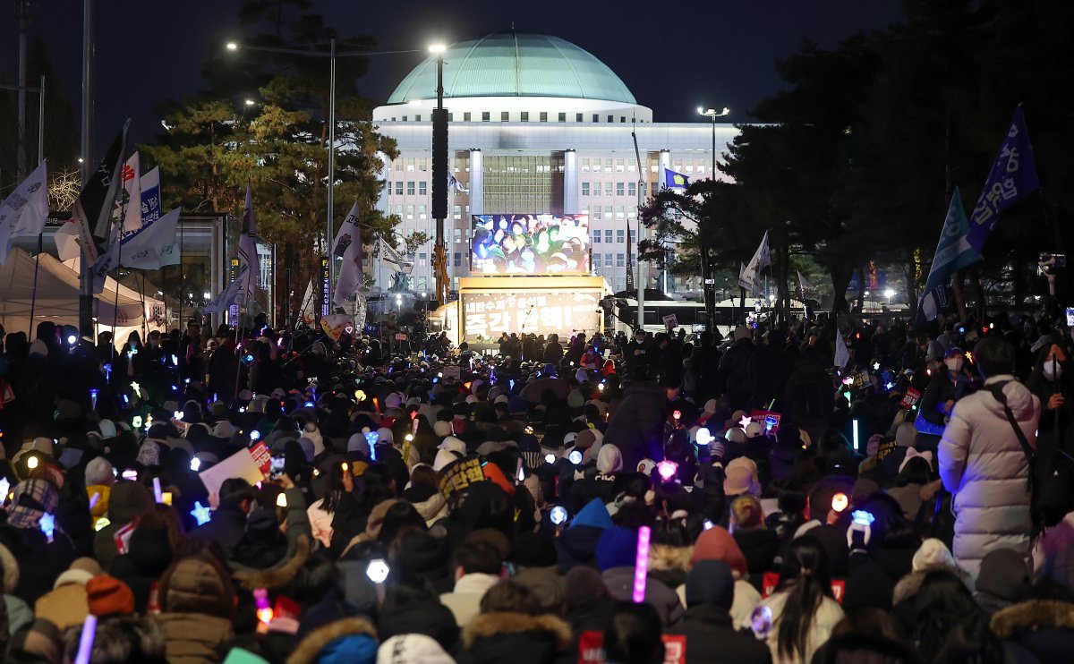 윤석열 대통령에 대한 국회의 2차 탄핵소추안 표결을 하루 앞둔 13일 오후 서울 영등포구 여의도 국회 앞에서 열린 ‘윤석열 즉각 탄핵 구속 촉구 촛불문화제’에서 참가자들이 응원봉과 손피켓을 들어 보이고 있다. 2024.12.13 뉴스1