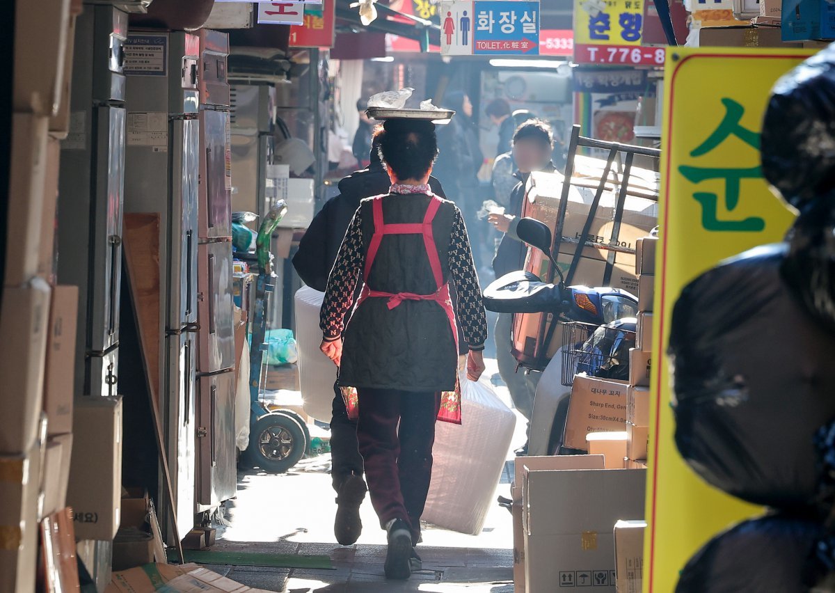 사진은 이날 서울 남대문 시장에서 한 상인이 점심 메뉴를 머리에 이고 배달하고 있다. 2024.12.23/뉴스1