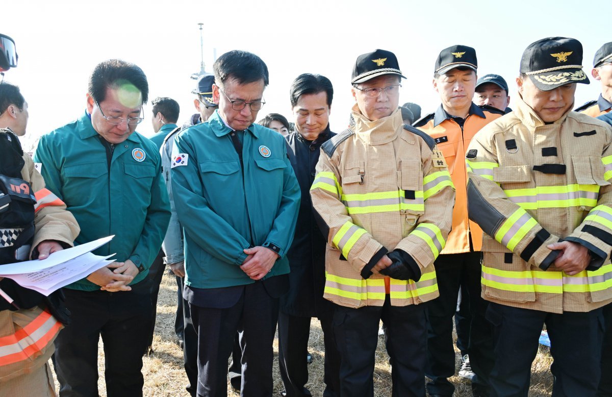 최상목 대통령 권한대행겸 기획재정부 장관이 29일 전남 무안공항 항공기 사고 현장을 방문해 묵념을 하고 있다.  기획재정부 제공