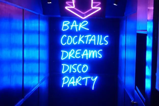 Insegna blu al neon con su scritto bar, cocktail, sogni, discoteca, party