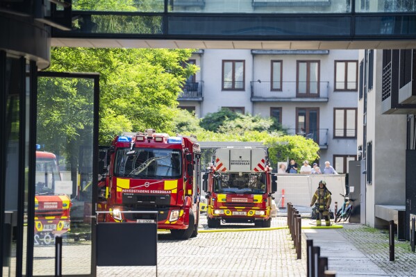 Firefighters work to extinguish a fire at the building housing the Danish Taxation Ministry, in Copenhagen, Denmark, Thursday June 27, 2024. A fire on Thursday broken out on top of a building housing Denmark’s Taxation Ministry in downtown Copenhagen, leading to the evacuation of the people inside the harbor-front glass-and-steel constrution and from adjacent houses. There was no word on casulaties.(Martin Sylvest/Ritzau Scanpix via AP)