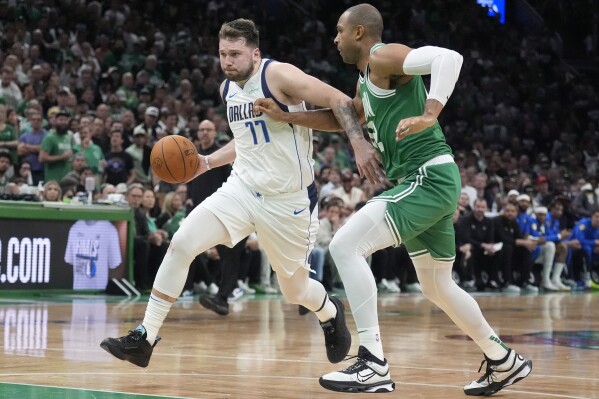 Dallas Mavericks guard Luka Doncic (77) drives against Boston Celtics center Al Horford, right, during the second half of Game 5 of the NBA basketball finals, Monday, June 17, 2024, in Boston. (AP Photo/Charles Krupa)