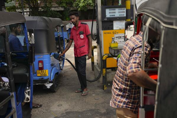 FILE- A man fills gas into a vehicle at a fuel station in Colombo, Sri Lanka, March 29, 2023. Sri Lanka’s president urged lawmakers Wednesday to approve a four-year International Monetary Fund program to restructure the country’s $17 billion in foreign debt. (AP Photo/Eranga Jayawardena, File)