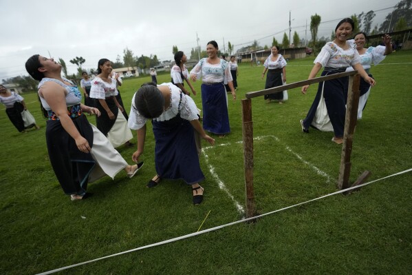 Caroly Blanco, left, misses an opportunity on goal during a "handball with anaco" match in the Indigenous community of Turucu, Ecuador, Friday, June 14, 2024. One year ago, a group of women decided to create a new version of soccer: handball with anaco, an ancient skirt worn by Indigenous women. (AP Photo/Dolores Ochoa)
