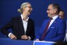 Alice Weidel, left, Federal Chairwoman of the AfD, and Tino Chrupalla, Federal Chairman of the AfD, talk at the start of the Alternative for Germany, Federal Party Conference in the Grugahalle in Essen, Germany, Saturday, June 29, 2024. At the two-day party conference, the AfD plans to elect a new federal executive committee, among other things. Numerous organizations have announced opposition to the meeting and more than a dozen counter-demonstrations. (Bernd von Jutrczenka/dpa via AP)
