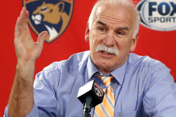 FILE - Florida Panthers head coach and former Chicago Blackhawks coach Joel Quenneville responds to a question during his first visit back to Chicago as a head coach before an NHL hockey game between the Blackhawks and the Panthers, Jan. 21, 2020. The NHL has reinstated executives Stan Bowman and Al MacIsaac and coach Quenneville. They are able to seek employment around the league effective immediately. Bowman, MacIsaac and Quenneville were banned from the league in October 2021 for their roles in the Blackhawks' mishandling of a video coach sexually assaulting a player in 2010. (AP Photo/Charles Rex Arbogast, File)