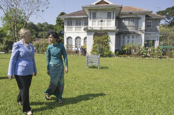 FILE - Myanmar's pro-democracy opposition leader Aung San Suu Kyi, right, and U.S. Secretary of State Hillary Rodham Clinton walk through the garden after meetings at Suu Kyi's residence in Yangon, Myanmar on Dec. 2, 2011. A court in military-controlled Myanmar has ordered that the family home of the country’s ousted leader Aung San Suu Kyi, where she spent 15 years under house arrest, be put on auction in March, issuing its ruling after a decades-long legal dispute between her and her brother. (AP Photo/Saul Loeb, Pool, File)