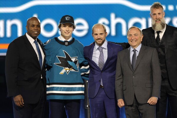 Macklin Celebrini, second from left, poses after being selected by San Jose Sharks during the first round of the NHL hockey draft Friday, June 28, 2024, in Las Vegas. (AP Photo/Steve Marcus)