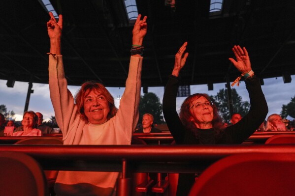 Beverly "Cookie" Grant and Ellen Shelburne watch George Thorogood & The Destroyers perform at Bethel Woods Center for the Arts, the site of Woodstock Music and Art Fair, Friday, June 14, 2024, in Bethel, N.Y. (AP Photo/Julia Nikhinson)