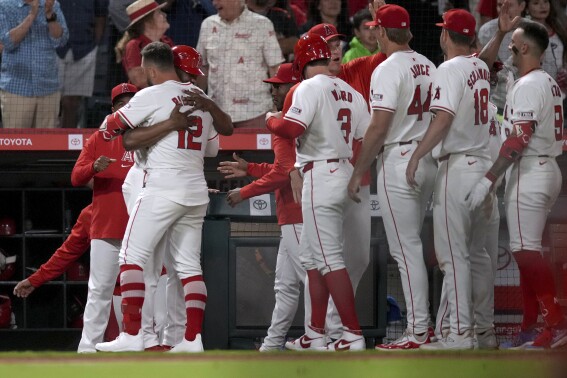 Los Angeles Angels designated hitter Kevin Pillar (12) is congratulated by teammates after he hit a single to drive in the winning run against the Detroit Tigers during the 10th inning of a baseball game in Anaheim, Calif., Saturday, June 29, 2024. (AP Photo/Eric Thayer)