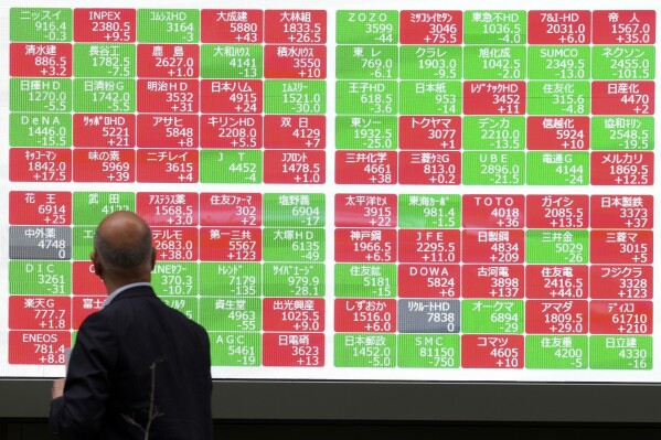 FILE - A person looks at an electronic stock board at a securities firm in Tokyo, on May 27, 2024. Asian stocks were mixed on Tuesday, June 11, in a busy week with several top-tier reports on U.S. inflation due along with a policy meeting of the Federal Reserve. (AP Photo/Eugene Hoshiko, File)