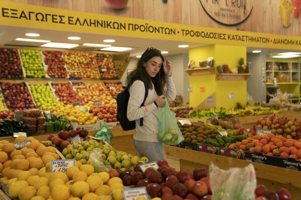 FILE - Personal trainer Antonia Kalantzi, 38, shops at a grocery store in Athens, Greece, on Feb. 16, 2022. The European economy contracted slightly at the end of last year and beginning of 2023, revised figures showed Thursday June 8, 2023, underlining the impact of the loss of Russian natural gas and high inflation on consumer spending. (AP Photo/Petros Giannakouris, File)