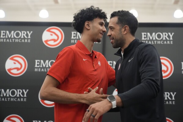 Atlanta Hawks' Zaccharie Risacher, left, and General Manager Landry Fields talk after an NBA basketball news conference, Friday, June 28, 2024, in Atlanta. Risacher was selected as the first overall pick by the Atlanta Hawks in the first round of the NBA basketball draft. (AP Photo/Brynn Anderson)