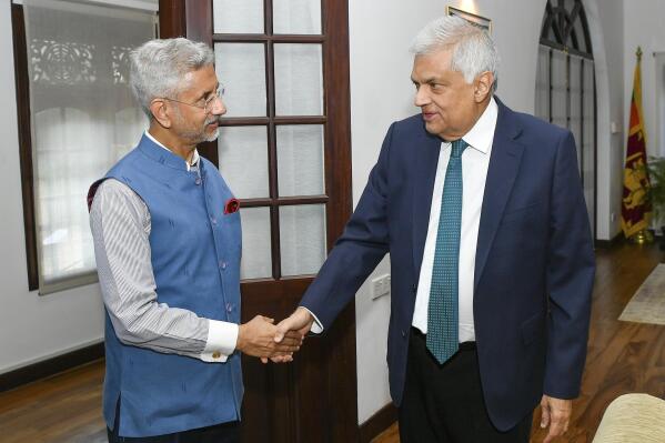 This handout photo provided by Sri Lankan President's Office shows President Ranil Wickremesinghe, right, shake hands with India’s Foreign Minister S. Jaishankar in Colombo, Sri Lanka, Friday, Jan. 20, 2023. Jaishankar said Friday his country has given financial assurances to the International Monetary Fund to facilitate a bailout plan to help neighboring Sri Lanka emerge from its worst economic crisis, in a first formal announcement from one of the island nation’s creditors. (Sri Lankan President's Office via AP)
