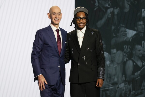 Rob Dillingham, right, poses for a photo with NBA commissioner Adam Silver after being selected by the San Antonio Spurs during the first round of the NBA basketball draft, Wednesday, June 26, 2024, in New York. (AP Photo/Julia Nikhinson)