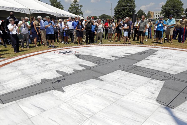 FILE - Family members and others look at a monument honoring the 15 Marines and one Navy corpsman who died in a July 10, 2017, U.S. military plane crash near Itta Bena, Miss., during an unveiling ceremony for the monument on July 14, 2018. Federal prosecutors said Wednesday, July 3, 2024, that a former engineer at a U.S. military air logistics center has been charged with making false statements and obstructing justice during the criminal investigation into the crash of the plane that had the call sign "Yanky 72." (AP Photo/Rogelio V. Solis, File)