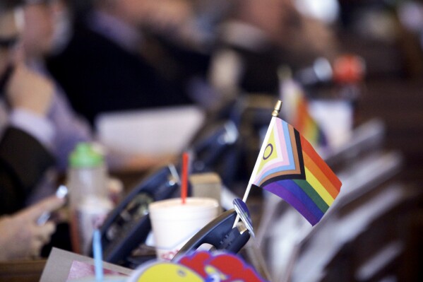 FILE - A flag supporting LGBTQ+ rights decorates a desk on the Democratic side of the Kansas House of Representatives during a debate, March 28, 2023, at the Statehouse in Topeka, Kan. The U.S. Supreme Court agreed Monday to consider whether a Tennessee ban on gender-affirming care for minors is constitutional. (AP Photo/John Hanna, File)