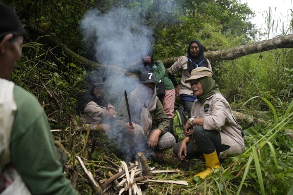 Rangers start a fire as they take a break during a forest patrol in Damaran Baru, Aceh province, Indonesia, Tuesday, May 7, 2024. The female-led group of forest rangers are defying social norms to lead patrols in the jungle to combat deforestation. (AP Photo/Dita Alangkara)