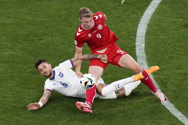 Denmark's Rasmus Hojlund, right, and Serbia's Nemanja Gudelj challenge for the ball during a Group C match between the Denmark and Serbia at the Euro 2024 soccer tournament in Munich, Germany, Tuesday, June 25, 2024. (AP Photo/Ariel Schalit)