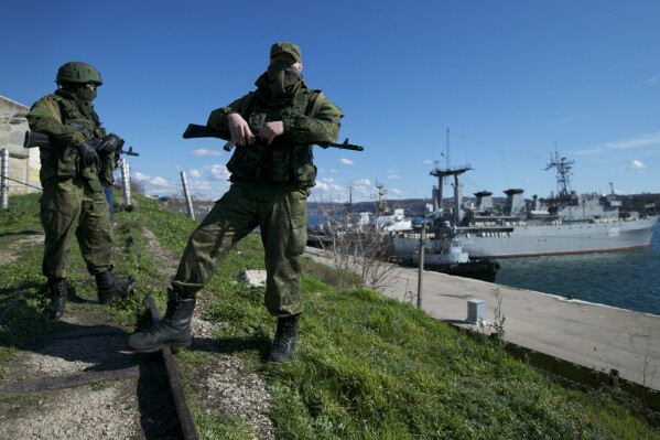 FILE - Russian soldiers guard a pier where two Ukrainian naval vessels are moored, in Sevastopol, Ukraine, on Wednesday, March 5, 2014. Europe's top human rights court ruled Tuesday, June 25, 2024, that Russia was responsible for a string of human rights violations in Crimea since overrunning and later illegally annexing the Black Sea peninsula in 2014. (AP Photo, File)