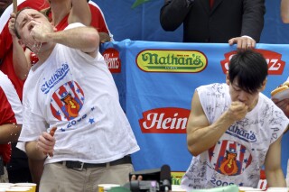 FILE - Joey Chestnut, defending champion of the Nathan’s Famous Fourth of July hot dog eating contest, left, works to outpace former champion Takeru Kobayashi, right, July 4, 2009, in New York. Chestnut, a 16-time hot dog-eating champion, will face off with his frequent Nathan’s competitor, Kobayashi, in a live Netflix special on Sept. 2, 2024, the streamer announced Wednesday, June 12. (AP Photo/Craig Ruttle, File)