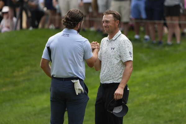 Cameron Young, left, celebrates with Jordan Spieth on the 18th green after they finished their round during the third round of the Travelers Championship golf tournament at TPC River Highlands, Saturday, June 22, 2024, in Cromwell, Conn. (AP Photo/Seth Wenig)