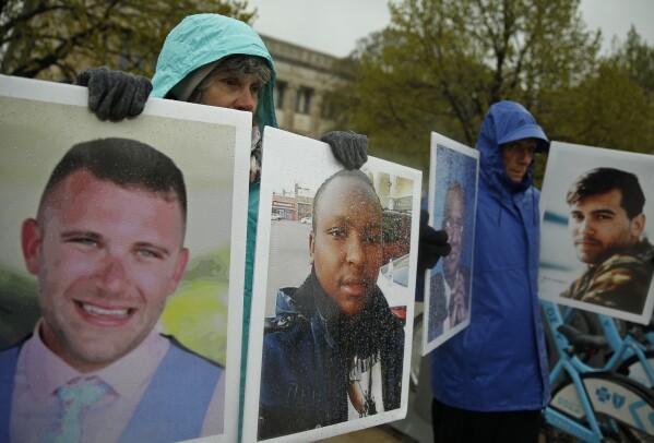 FILE - Protesters hold photographs of victims, including Melvin Riffel, left, of the 2019 Ethiopian Airlines plane crash, outside Boeing's annual shareholders meeting in Chicago on April 29, 2019. Ike Riffel, a California father whose two sons, Melvin and Bennett, died in the crash, fears that instead of putting Boeing on trial, the government will offer the company another shot at corporate probation through a legal document called a deferred prosecution agreement, or DPA. (AP Photo/Jim Young, File)