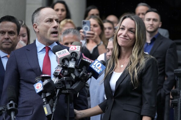 Karen Read, right, smiles as defense attorney David Yannetti, front left, speaks to reporters in front of Norfolk Superior Court after the judge declared a mistrial after jurors were unable to reach a verdict following a two-month trial, Monday, July 1, 2024, in Dedham, Mass. (AP Photo/Steven Senne)