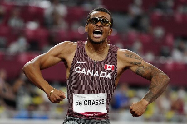 FILE - Canada's Andre De Grasse races to a gold medal in the Men's 200m final during the Tokyo Olympics in Tokyo, Japan, Wednesday, Aug. 4, 2021. De Grasse manages to stay under the radar most of the time, but has a knack for turning up big when the lights are shining the brightest. (Frank Gunn/The Canadian Press via AP, File)