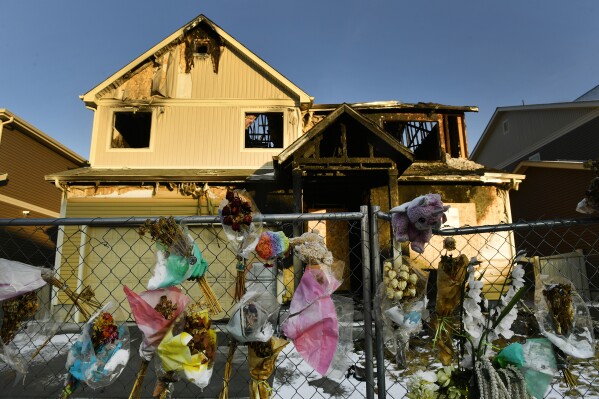 FILE - The house where five Senegalese immigrants were murdered in a fire is surrounded by old bouquets, stuffed animals and other remembrances, Jan. 27, 2021, in Denver. Kevin Bui could be sentenced to 60 years in prison, Tuesday, July 2, 2024, after pleading guilty to murder charges for starting the 2020 fire. (Helen H. Richardson/The Denver Post via AP, File)