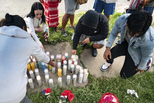 People light candles on the sidewalk during a vigil for 13-year-old Nyah Mway in Utica, N.Y., Saturday, June 29, 2024. On Friday, June 28, Mway was fatally shot by police who’d tackled him to the ground after he allegedly pointed what turned out to be a BB gun at them during a foot chase. (Daniel DeLoach/Observer-Dispatch via AP)