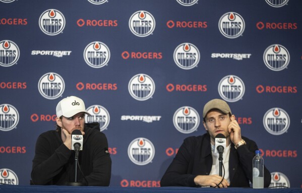 Edmonton Oilers' Connor McDavid, left and Leon Draisaitl speak during a press conference after getting back from losing to the Florida Panthers in Game 7 of the NHL Stanley Cup hockey final, in Edmonton on Wednesday June 26, 2024. (Jason Franson/The Canadian Press via AP)