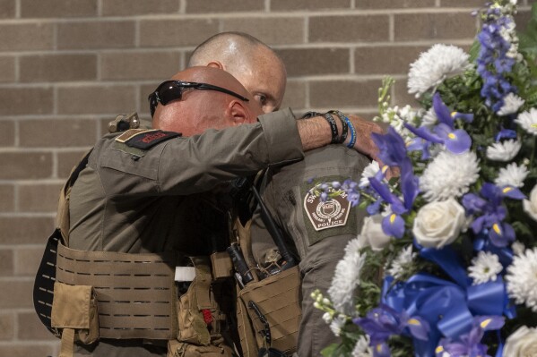 SLED Senior Agent Richard 'Cole' Powell is embraced by teammate Lt. Keith Thrower during a memorial service for Powel's K9 partner, Coba, on Wednesday, June 19, 2024, Columbia, S.C. (Tracy Glantz/The State via AP)