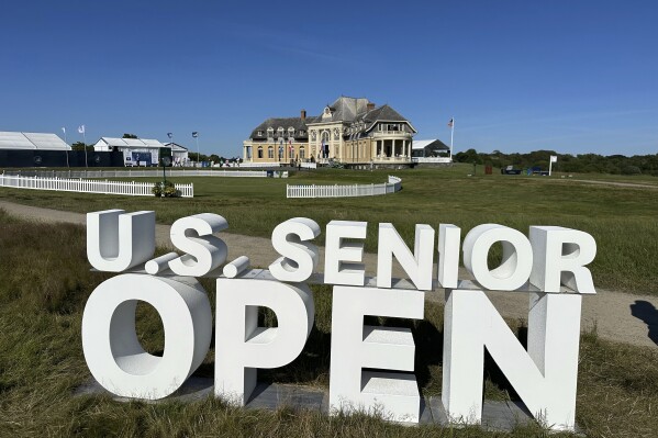 The clubhouse at the Newport Country Club is visible Friday, June 28, 2024, behind a sign for the U.S. Senior Open which is being played June 27-30 in Newport, R.I. (AP Photo/Jimmy Golen)